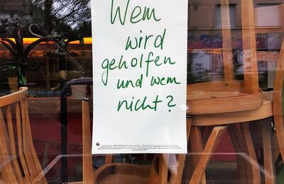 Zettel im Restaurantfenster "Wem wird geholfen und wem nicht?"